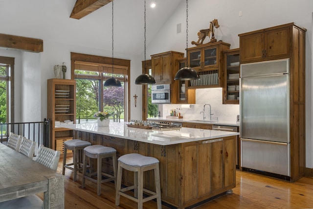 1007 Headwaters Dr, Marshfield, MO 65706 - kitchen with stainless steel appliances, a sink, a center island, hardwood / wood-style flooring, and light countertops