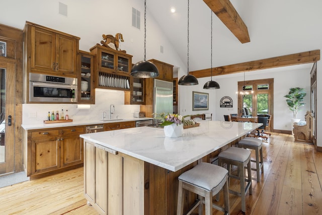 1007 Headwaters Dr, Marshfield, MO 65706 - kitchen featuring a sink, appliances with stainless steel finishes, light wood-style flooring, beamed ceiling, and a kitchen bar