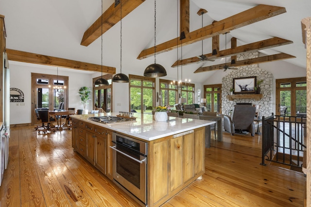 1007 Headwaters Dr, Marshfield, MO 65706 - kitchen featuring appliances with stainless steel finishes, light wood-style floors, beam ceiling, hanging light fixtures, and plenty of natural light