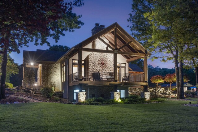 1007 Headwaters Dr, Marshfield, MO 65706 - back of house with stone siding, a chimney, and a lawn