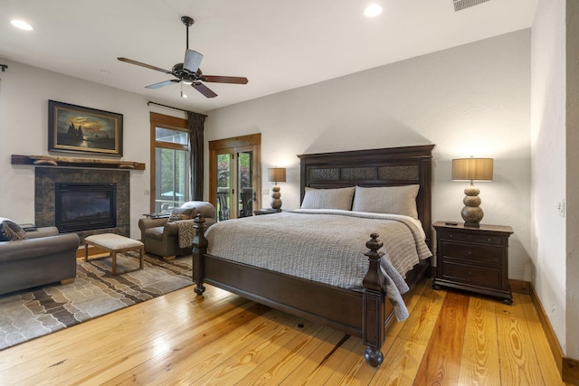 1007 Headwaters Dr, Marshfield, MO 65706 - bedroom featuring wood finished floors, a tiled fireplace, baseboards, recessed lighting, and ceiling fan