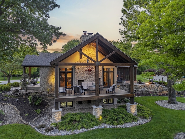 1007 Headwaters Dr, Marshfield, MO 65706 - back of property with stone siding, a chimney, and a yard