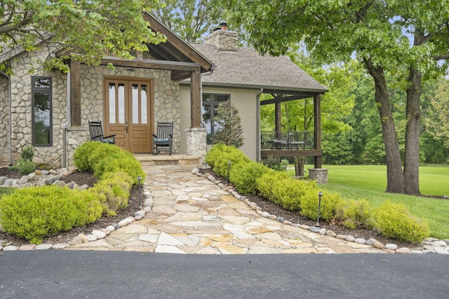 1007 Headwaters Dr, Marshfield, MO 65706 - view of front of house featuring stone siding, a chimney, roof with shingles, a front lawn, and covered porch