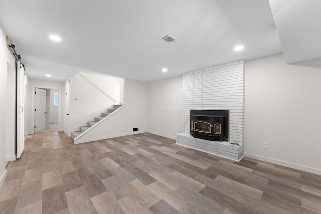 25609 Hillcrest Dr, Shell Knob, MO 65747 - unfurnished living room featuring recessed lighting, stairway, a barn door, light wood-style floors, and baseboards
