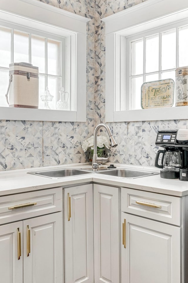 1200 E Walnut St, Springfield, MO 65802 - kitchen featuring backsplash, light countertops, a sink, and white cabinets