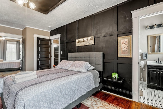 1200 E Walnut St, Springfield, MO 65802 - bedroom with dark wood-style floors, a sink, ornamental molding, and baseboards