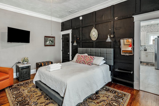1200 E Walnut St, Springfield, MO 65802 - bedroom with freestanding refrigerator, wood finished floors, ornamental molding, and baseboards