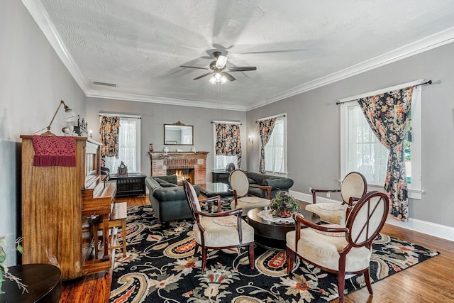 1200 E Walnut St, Springfield, MO 65802 - living area with a ceiling fan, a brick fireplace, wood finished floors, baseboards, and crown molding