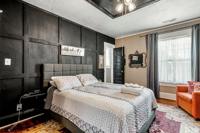 1200 E Walnut St, Springfield, MO 65802 - bedroom with wood finished floors, baseboards, and a textured ceiling