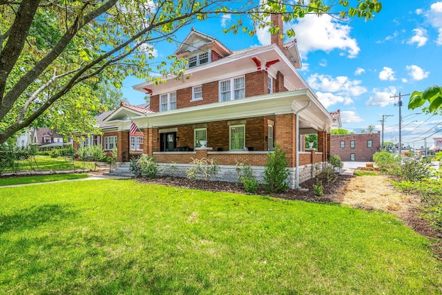 1200 E Walnut St, Springfield, MO 65802 - american foursquare style home featuring covered porch, brick siding, a front lawn, and a chimney