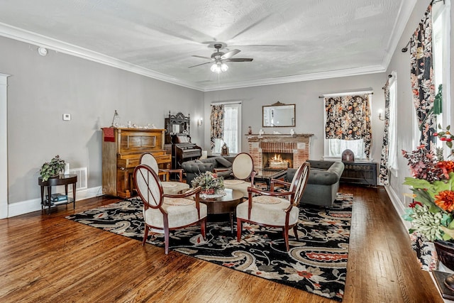 1200 E Walnut St, Springfield, MO 65802 - living area featuring ceiling fan, hardwood / wood-style floors, a brick fireplace, baseboards, and ornamental molding