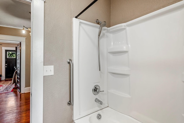 1200 E Walnut St, Springfield, MO 65802 - bathroom with a textured wall, wood finished floors, and shower / bathtub combination