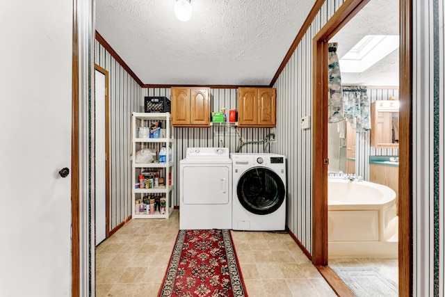 1161 State Highway 176, Rockaway Beach, MO 65740 - laundry room with a textured ceiling, washer and clothes dryer, wallpapered walls, cabinet space, and ornamental molding