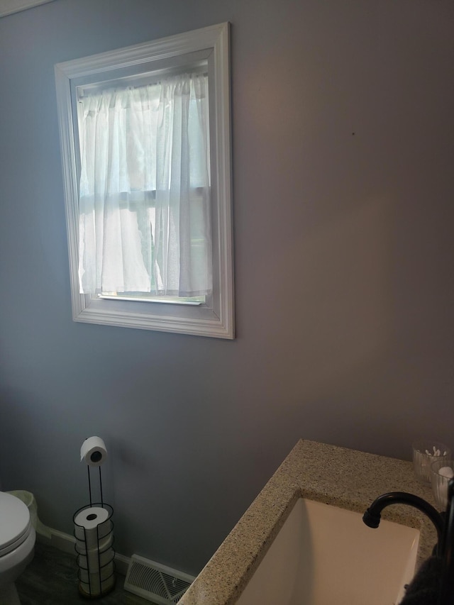 511 3rd St, Mccune, MO 66753 - bathroom with baseboards, toilet, and a sink