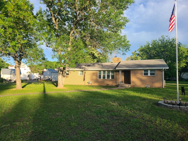 511 3rd St, Mccune, MO 66753 - view of front of home with a front lawn, a chimney, and brick siding
