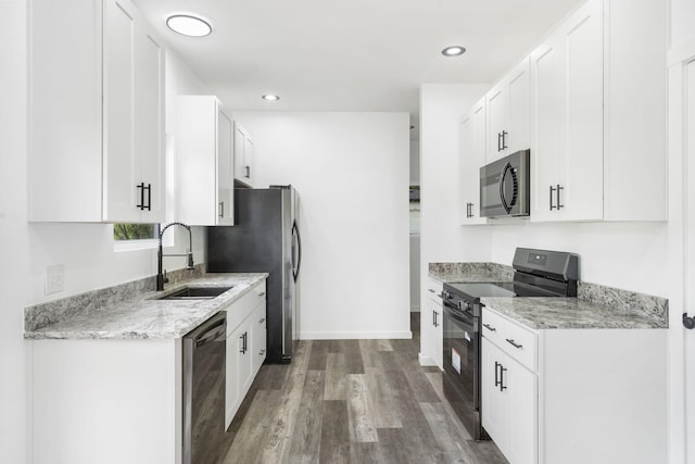806 Iris Ave, Crane, MO 65633 - kitchen with appliances with stainless steel finishes, a sink, wood finished floors, white cabinetry, and light stone counters