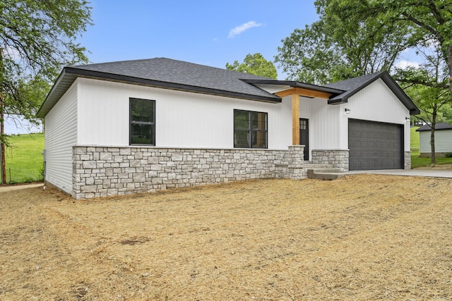 806 Iris Ave, Crane, MO 65633 - view of front facade featuring stone siding, an attached garage, a shingled roof, and concrete driveway