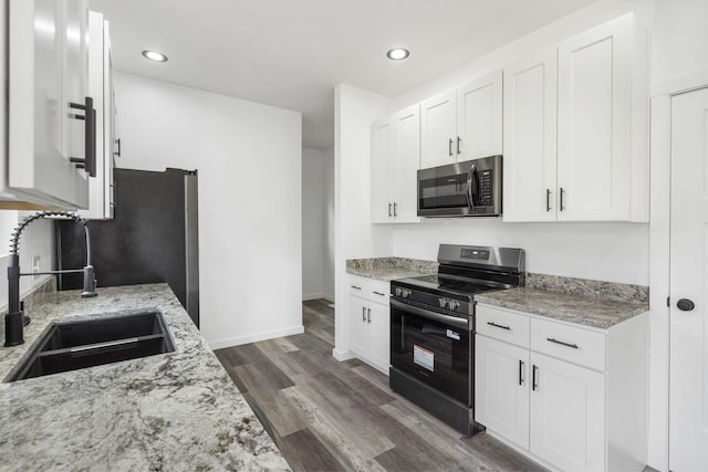 806 Iris Ave, Crane, MO 65633 - kitchen featuring appliances with stainless steel finishes, a sink, dark wood finished floors, white cabinetry, and recessed lighting