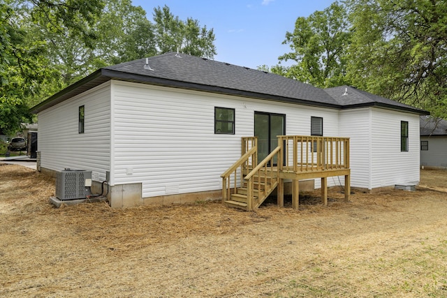 806 Iris Ave, Crane, MO 65633 - back of property featuring central AC unit, a deck, and roof with shingles