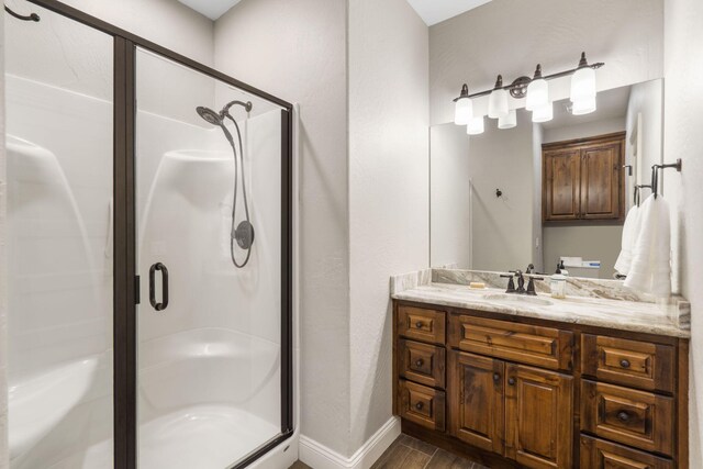 4936 S Butterfield Pl, Brookline, MO 65619 - bathroom featuring wood finished floors, a stall shower, vanity, and baseboards