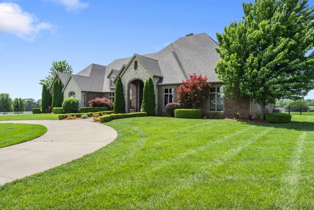 3731 S Farm Rd Unit 219, Rogersville, MO 65742 - french country home with stone siding, curved driveway, and a front yard