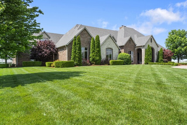 3731 S Farm Rd Unit 219, Rogersville, MO 65742 - french country home with stone siding, a chimney, brick siding, and a front yard