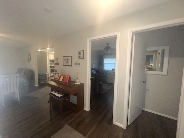 608 N Chapman St, Anderson, MO 64831 - hallway with dark wood-type flooring, a desk, and baseboards
