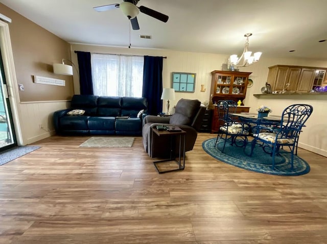 123 River Point Rd Unit 33, Hollister, MO 65672 - living area featuring a ceiling fan, a chandelier, wood finished floors, and wainscoting