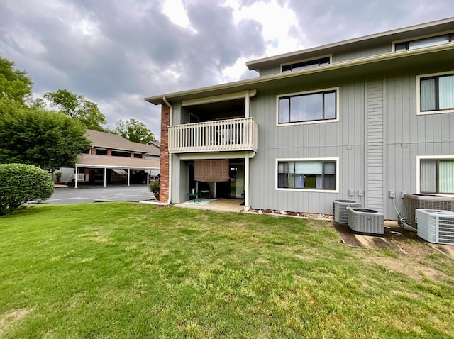 123 River Point Rd Unit 33, Hollister, MO 65672 - back of property featuring central AC unit, a balcony, and a lawn