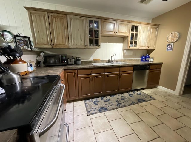 123 River Point Rd Unit 33, Hollister, MO 65672 - kitchen featuring appliances with stainless steel finishes, a sink, dark countertops, and light tile patterned flooring