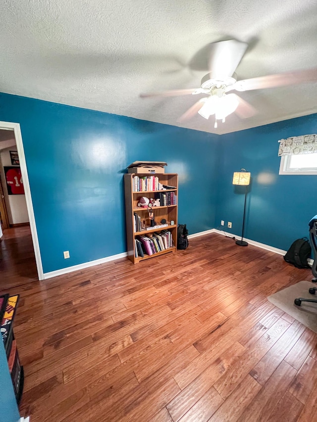 21650 Kings Loop, Hermitage, MO 65668 - home office featuring a textured ceiling, wood finished floors, ceiling fan, and baseboards