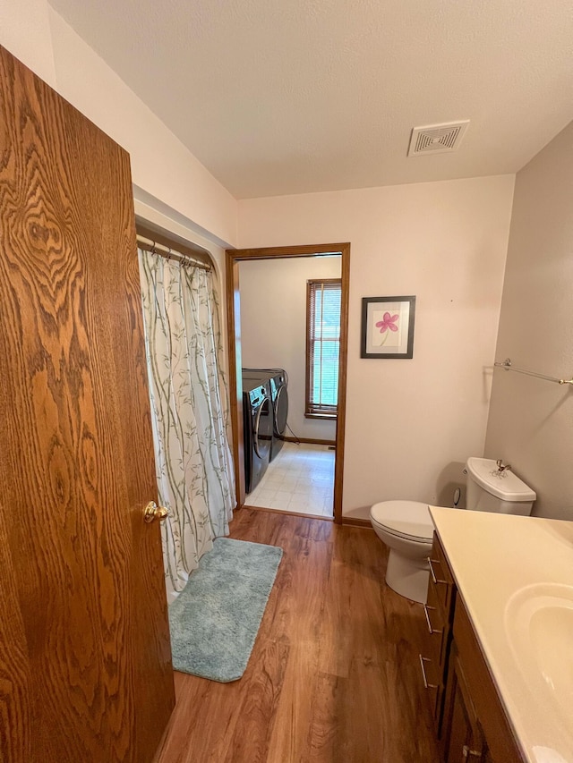 21650 Kings Loop, Hermitage, MO 65668 - full bath featuring washing machine and clothes dryer, wood finished floors, toilet, vanity, and a shower with curtain