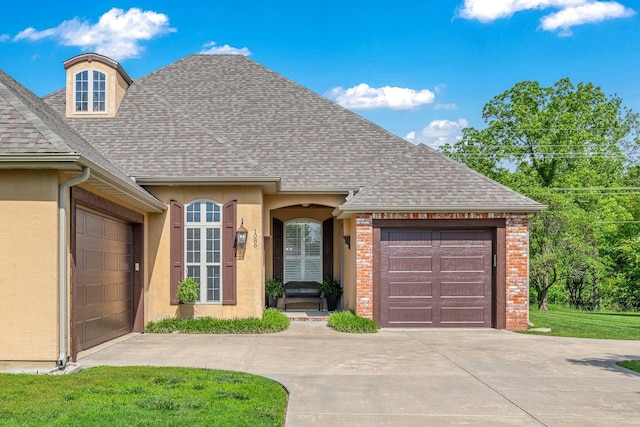 1086 S Joshua Ave, Republic, MO 65738 - view of front of home with an attached garage, driveway, a shingled roof, and stucco siding