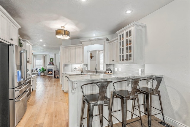 1086 S Joshua Ave, Republic, MO 65738 - kitchen featuring high quality fridge, tasteful backsplash, glass insert cabinets, a breakfast bar area, and recessed lighting