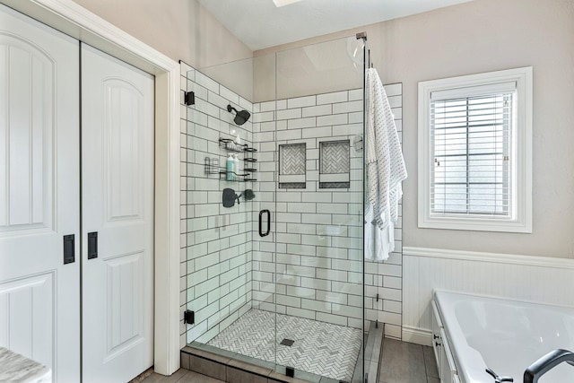 1086 S Joshua Ave, Republic, MO 65738 - bathroom with a garden tub, a stall shower, wainscoting, and tile patterned flooring