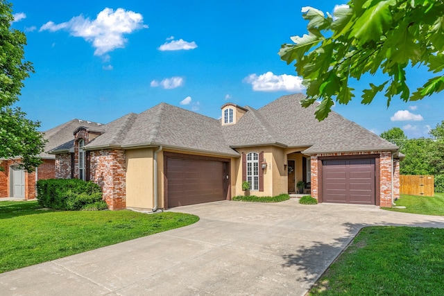 1086 S Joshua Ave, Republic, MO 65738 - french country style house featuring a garage, concrete driveway, stucco siding, a shingled roof, and brick siding