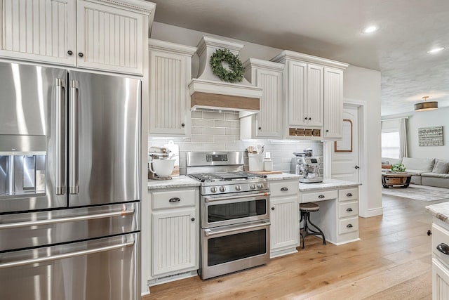 1086 S Joshua Ave, Republic, MO 65738 - kitchen featuring stainless steel appliances, custom range hood, open floor plan, backsplash, and light wood-style flooring
