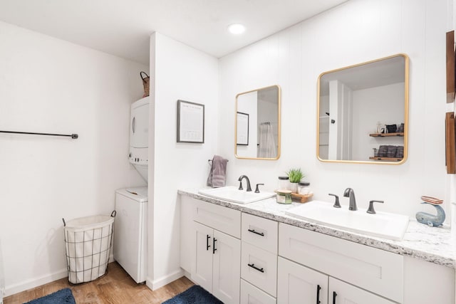 96 Samson St, Cape Fair, MO 65624 - bathroom featuring estacked washer and dryer, wood finished floors, double vanity, and baseboards