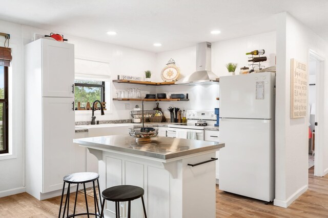 96 Samson St, Cape Fair, MO 65624 - kitchen with white appliances, wall chimney exhaust hood, stainless steel counters, a kitchen breakfast bar, and white cabinets