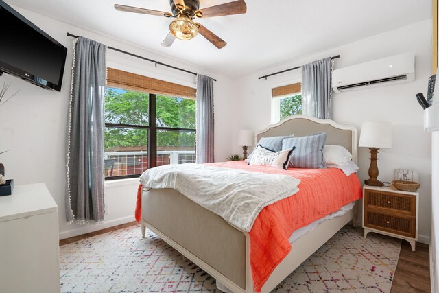 96 Samson St, Cape Fair, MO 65624 - bedroom with a wall mounted AC, wood finished floors, ceiling fan, and baseboards