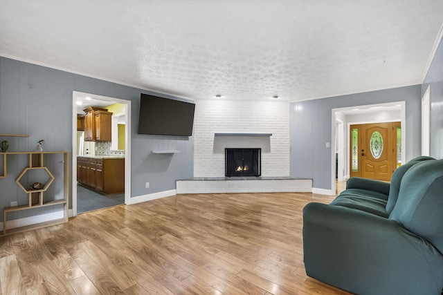 1514 W Swan St, Springfield, MO 65807 - living area featuring light wood-type flooring, a fireplace, a textured ceiling, and ornamental molding