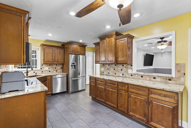 1514 W Swan St, Springfield, MO 65807 - kitchen featuring ceiling fan, appliances with stainless steel finishes, a sink, backsplash, and light stone countertops