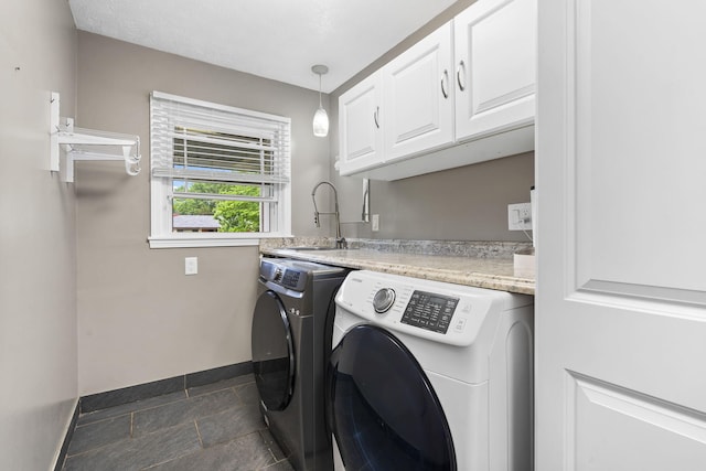 1514 W Swan St, Springfield, MO 65807 - washroom with cabinet space, washer and clothes dryer, baseboards, and dark stone finish floors