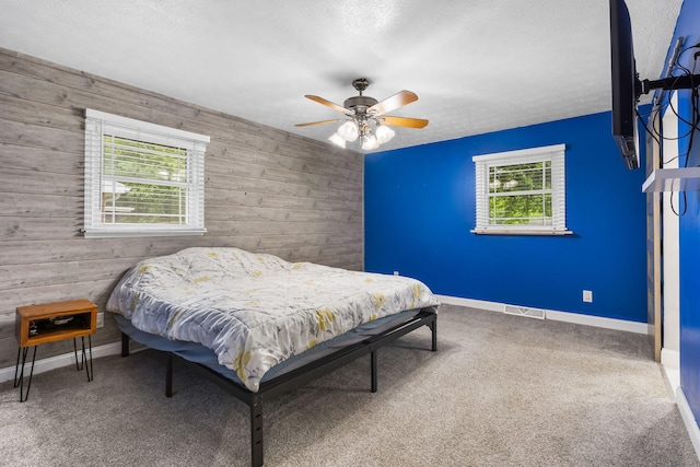 1514 W Swan St, Springfield, MO 65807 - bedroom with multiple windows, wood walls, baseboards, carpet flooring, and ceiling fan