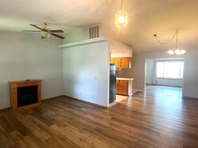 607 Robin Rd, Mountain Grove, MO 65711 - unfurnished living room with wood finished floors, a chandelier, a ceiling fan, lofted ceiling, and baseboards