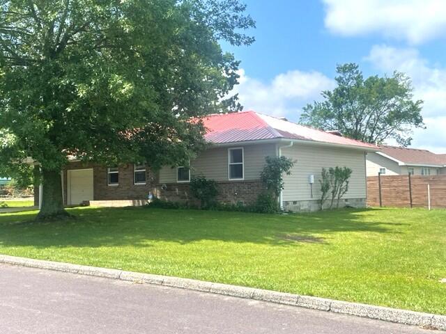 607 Robin Rd, Mountain Grove, MO 65711 - view of side of home with an attached garage, metal roof, and crawl space