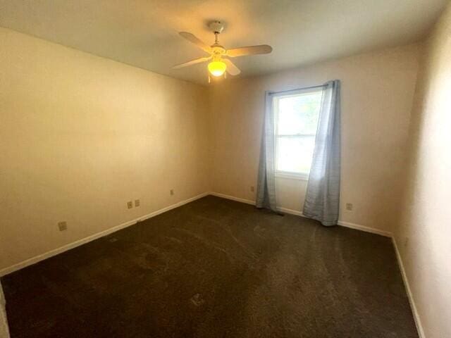 607 Robin Rd, Mountain Grove, MO 65711 - spare room featuring baseboards, a ceiling fan, and dark carpet