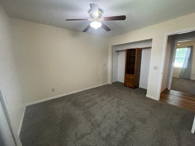 607 Robin Rd, Mountain Grove, MO 65711 - unfurnished bedroom featuring dark carpet, baseboards, a closet, and a ceiling fan