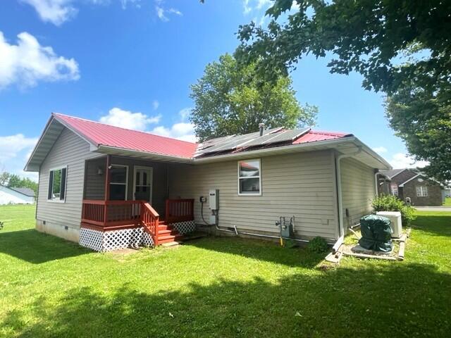 607 Robin Rd, Mountain Grove, MO 65711 - rear view of house featuring roof mounted solar panels, a lawn, a porch, metal roof, and crawl space