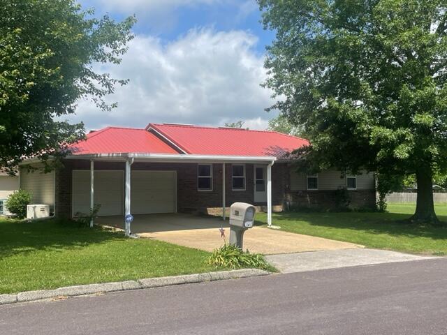607 Robin Rd, Mountain Grove, MO 65711 - single story home featuring a garage, concrete driveway, a front lawn, and metal roof